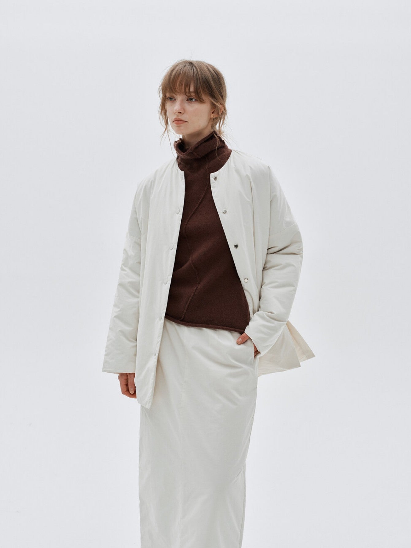 Eliraya white split-hem puffer jacket for women, designed for warmth and style with thick padding and a modern look for winter.